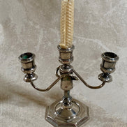 Close detail of stepped octagonal base on silver plate three-light candelabra