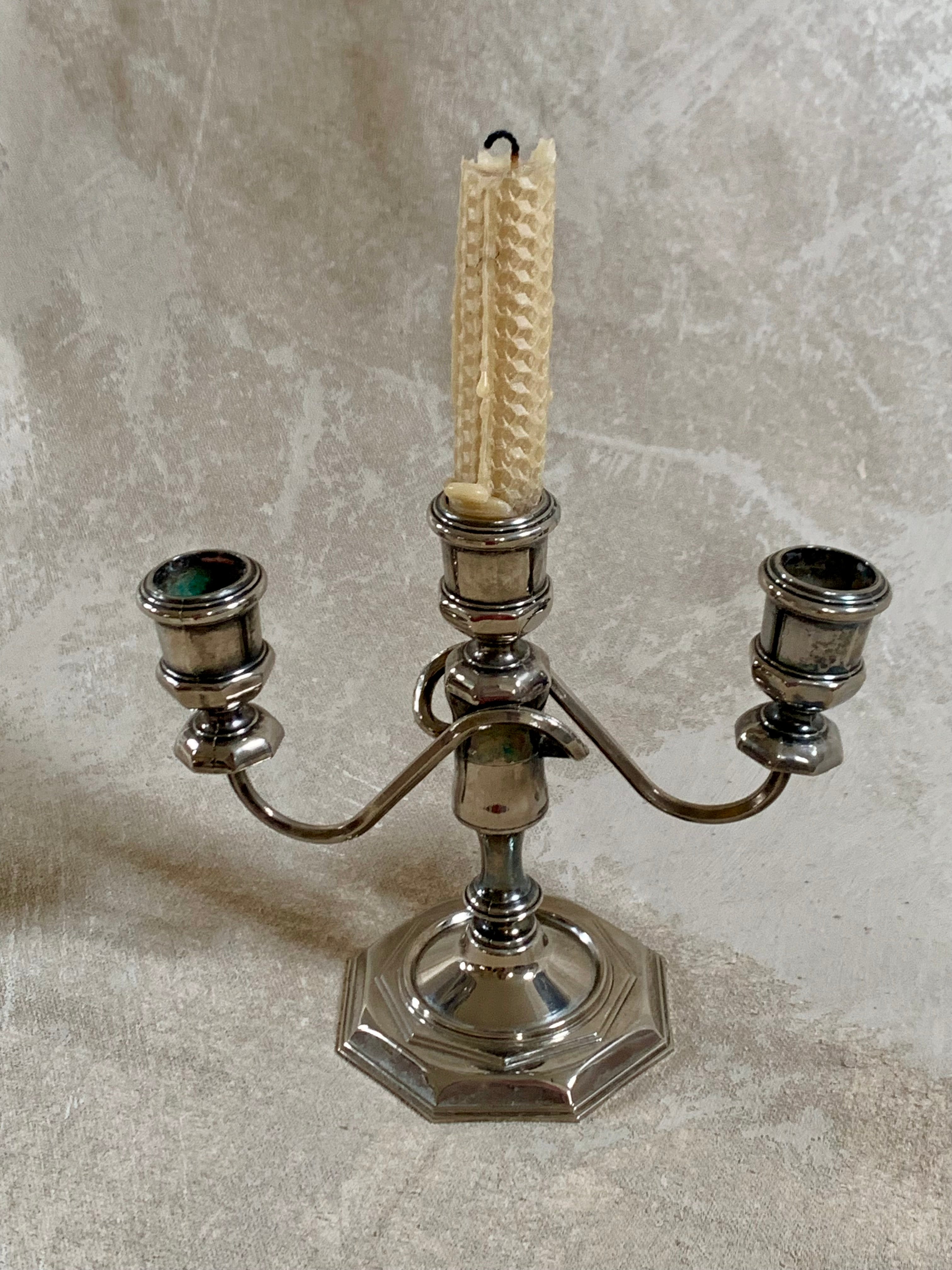 Close detail of stepped octagonal base on silver plate three-light candelabra