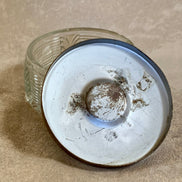 Enamel lid detail of Art Deco powder jar showing gilt cartouche and gold stripe — 1920s–1930s