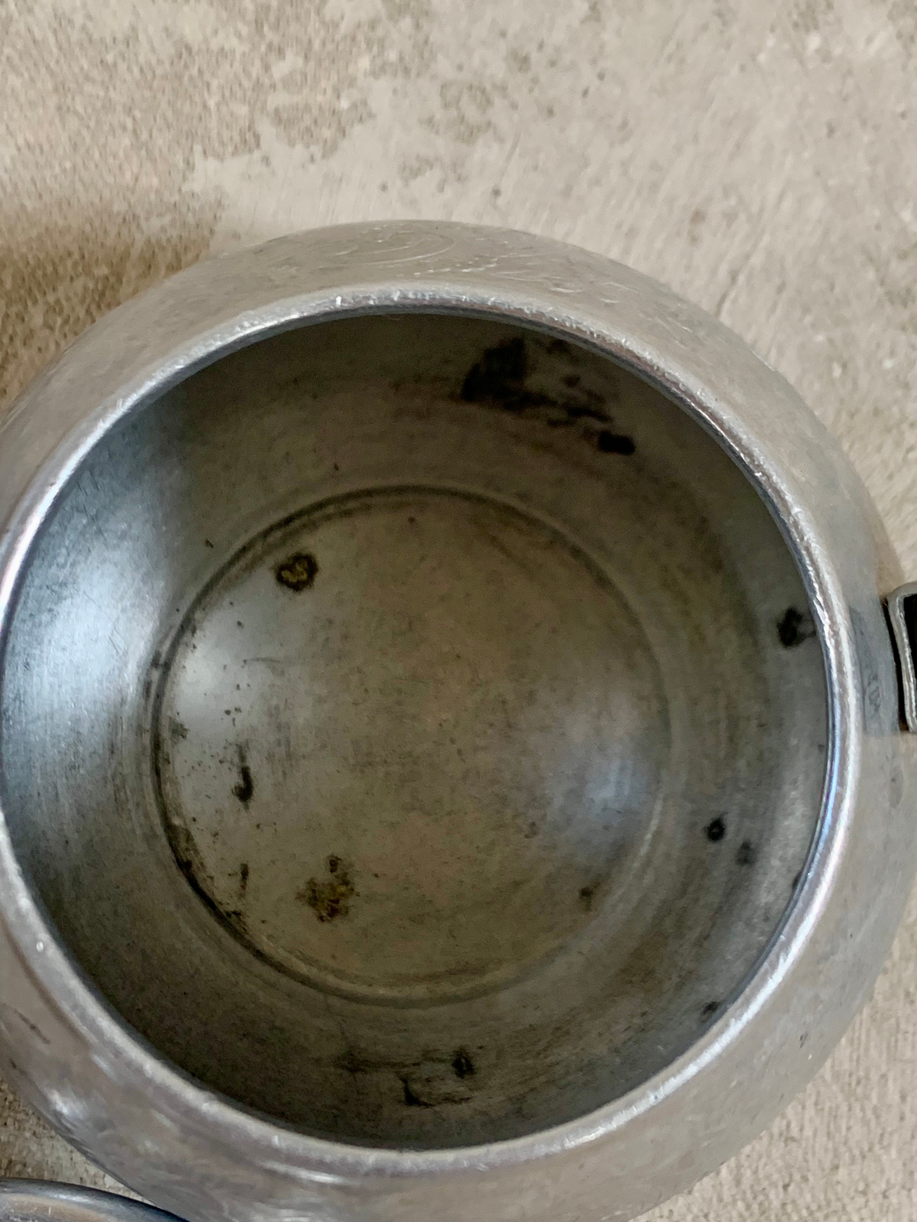 Three-quarter view of Carlton aluminum teapot showing full etched band and handle profile — Jolene Le Mille Archive