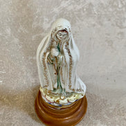 Gold scrollwork border detail on white crackle glaze ceramic Fatima figurine — hand-applied, 1950s