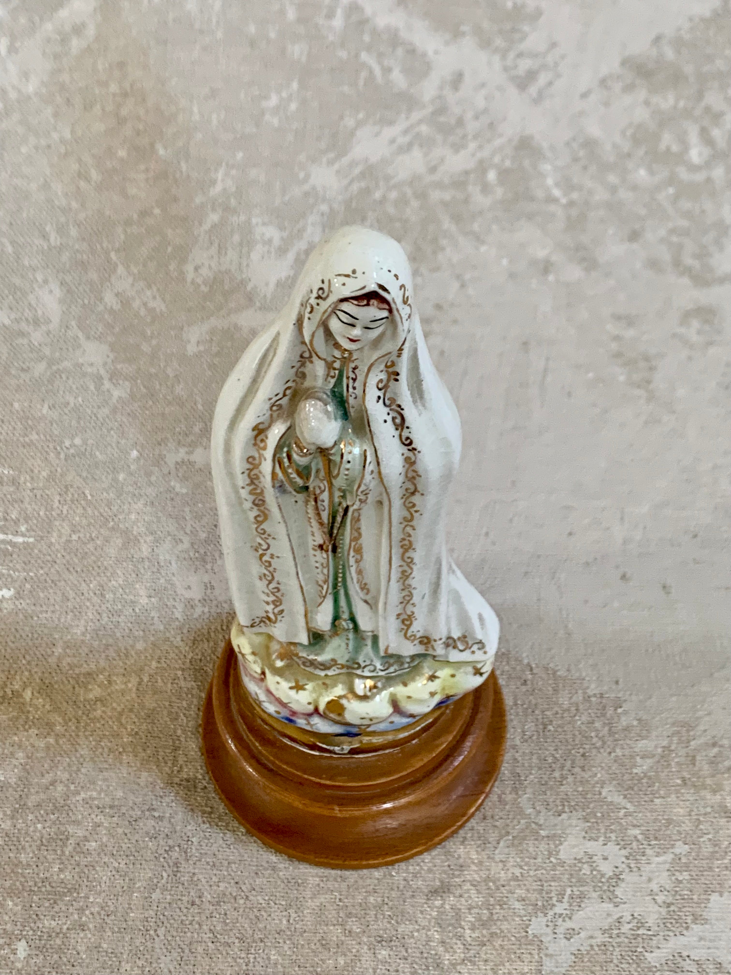 Gold scrollwork border detail on white crackle glaze ceramic Fatima figurine — hand-applied, 1950s
