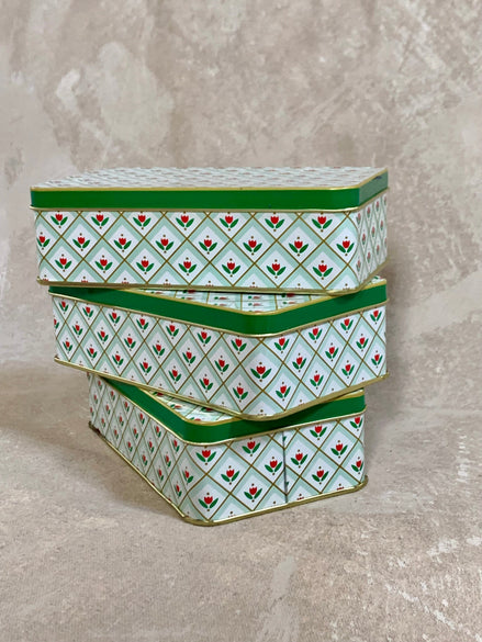 Three graduated storage tins separated showing size range — red tulip and gold diamond lattice on mint green, European 1960s–1970s