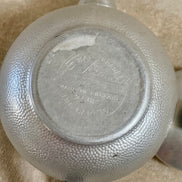 Stylized floral and acanthus engraving detail on Swan Brand Carlton aluminum body — hand-tooled, 1950s
